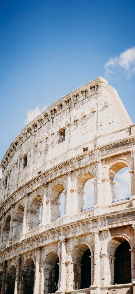 Colosseum In Rome Beneath The Clear Blue Sky Wallpaper