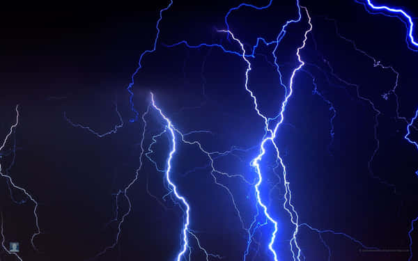 Download Blue Lightning Strikes Against a Pitch-Black Sky | Wallpapers.com