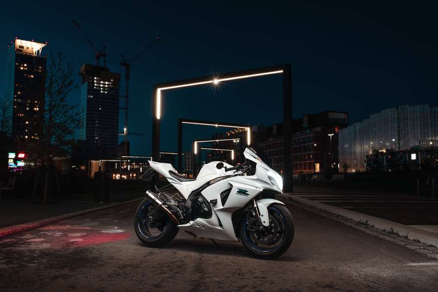 White sport motorcycle parked on city street at night under glowing neon arches. — 1920x1080 Motorcycle Wallpaper