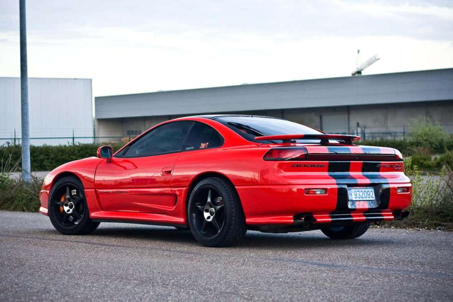 Red Dodge Viper sports car with racing stripes parked outdoors near industrial buildings. — 1991 Dodge Stealth Wallpaper