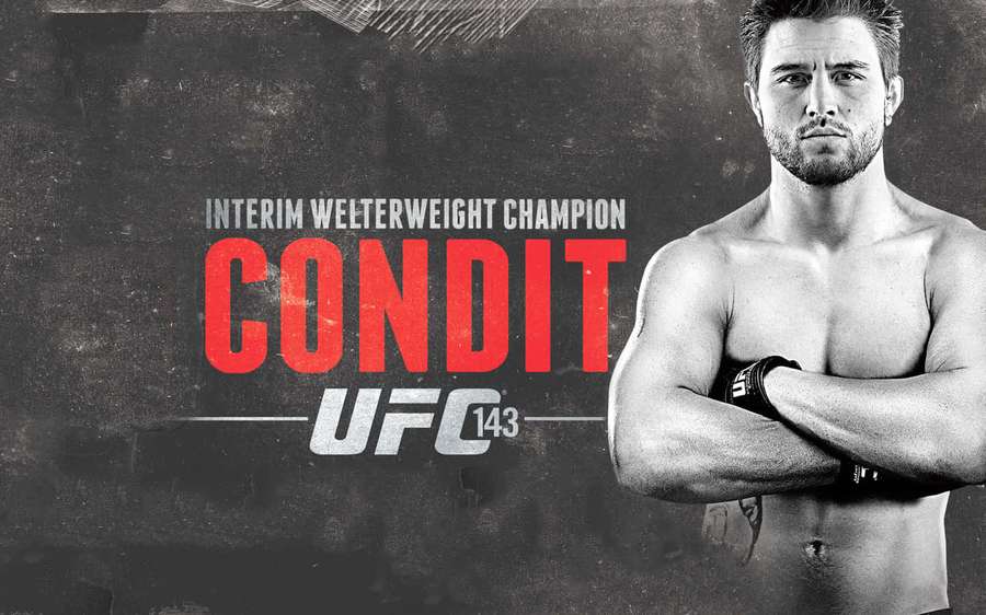 Oberkörperfreier UFC-Kämpfer mit verschränkten Armen, vor einer strukturierten Wand mit Meisterschaftstext. — 21:9 Wallpaper