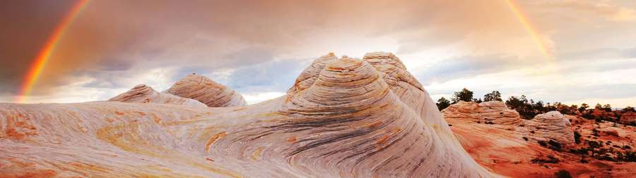 Double rainbow over uniquely shaped desert rock formations at sunset. — 2732x768 Wallpaper