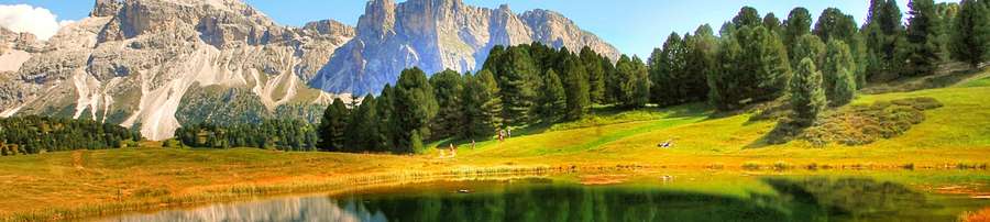 Alpine lake reflecting mountains and forest under blue sky — 4K Nature Background