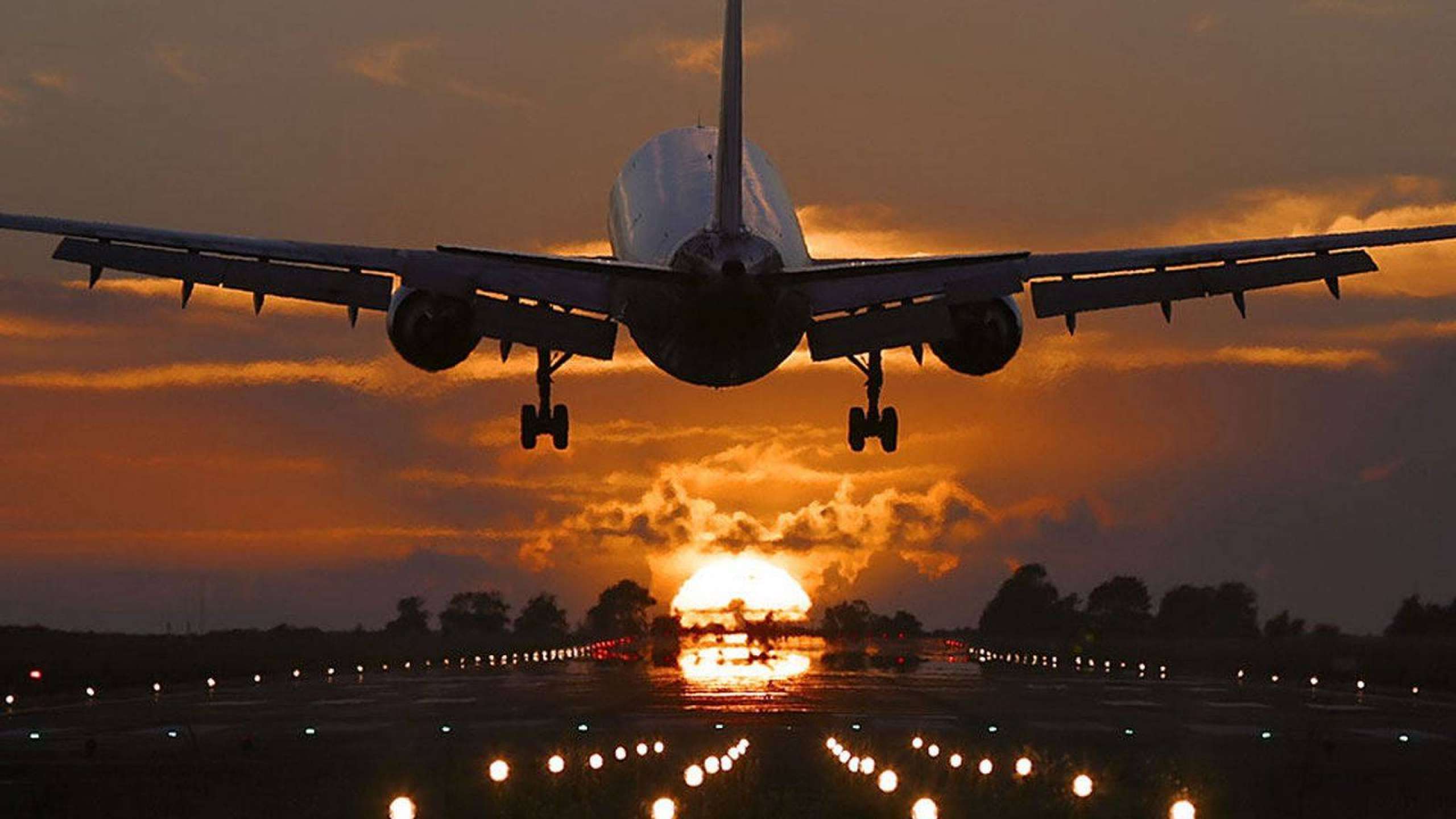 Airplane landing at sunset with runway lights glowing — 4K Plane Background