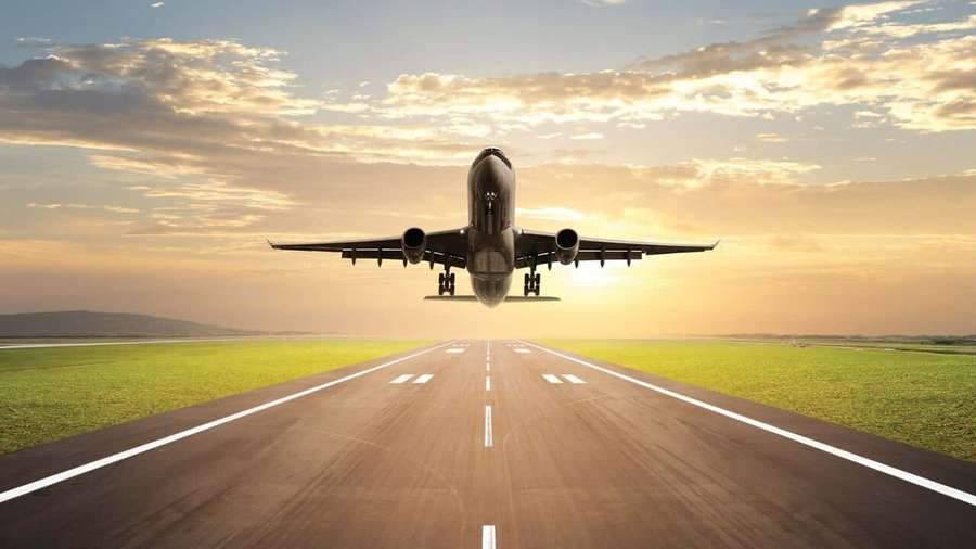 An airplane taking off from a runway at sunset with green fields and golden sky. — 720p Plane Background
