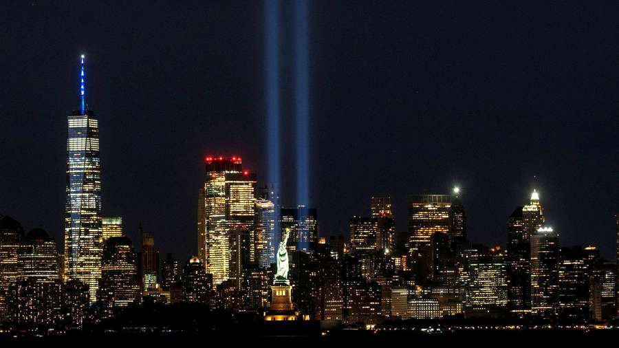 New York City skyline at night with two tribute beams and Statue of Liberty lit. — 911 Memorial Wallpaper