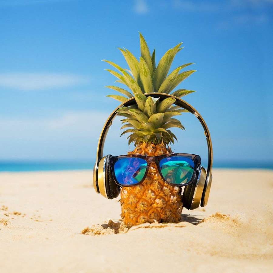 Abacaxi com óculos de sol e fones de ouvido em uma praia ensolarada. — Abacaxi Papéis de Parede