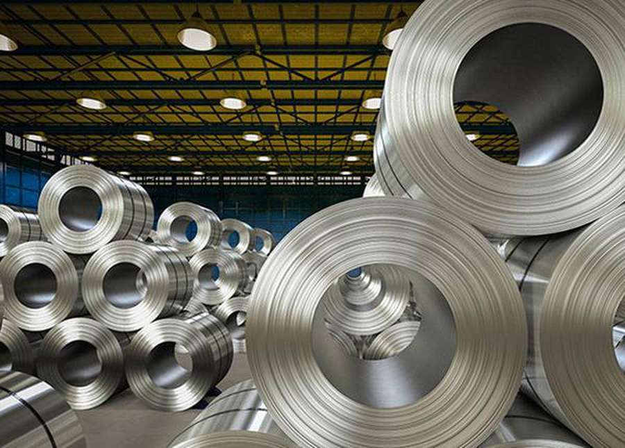 Grandes bobinas de aço empilhadas em um armazém industrial com vigas de teto amarelas. — Aço Papéis de Parede