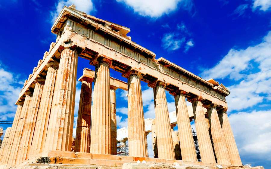 Ancient Greek temple with tall columns under bright blue sky with clouds — Acropolis Wallpaper