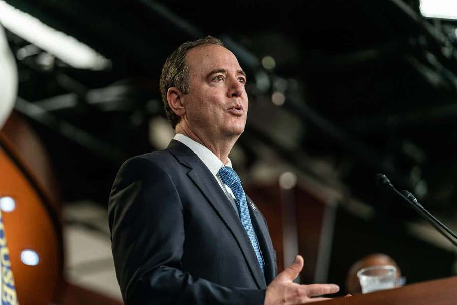 Man in suit giving speech at podium indoors under stage lights — Adam Schiff Wallpaper