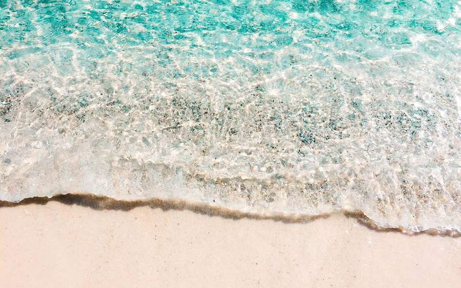 Turquoise ocean waves washing over pale pink sand at a tropical beach. — Aesthetic Summer Background