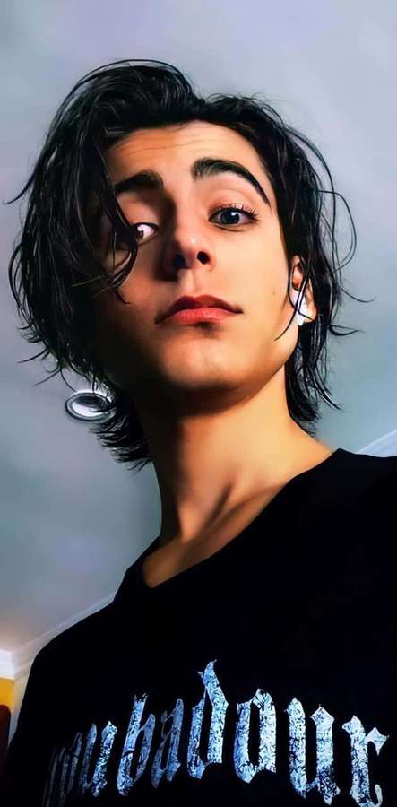 Young man with dark hair and intense eyes wearing a black t-shirt with blue text. — Aidan Gallagher Wallpaper