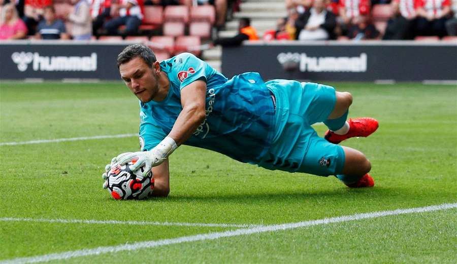 Goleiro de futebol mergulhando para pegar uma bola em um campo de grama. — Alex Mccarthy Papéis de Parede