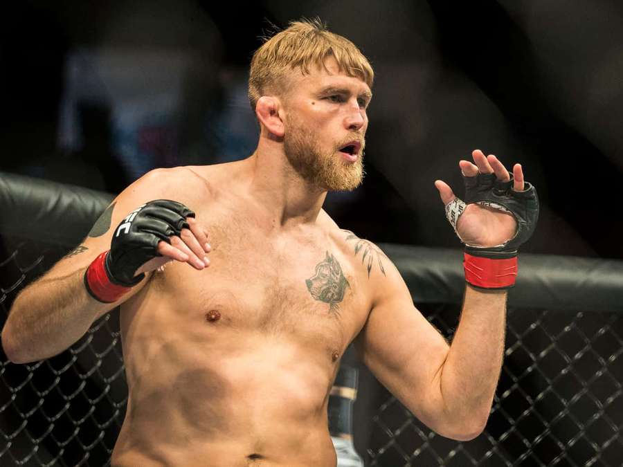 En bar overkropp MMA-fighter med skjegg og tatoveringer inne i et åttekantet bur. — Alexander Gustafsson Bakgrunner