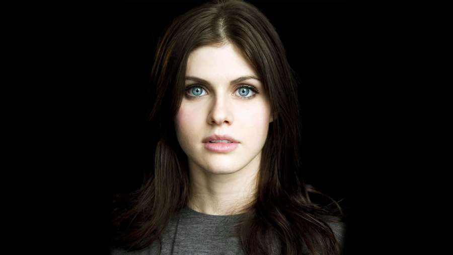 Close-up portrait of a woman with blue eyes and dark hair against black background. — Alexandra Daddario Background