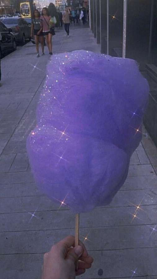 Mano sosteniendo algodón de azúcar púrpura brillante en la acera con personas y coches. — Algodón Morado Fondos de pantalla