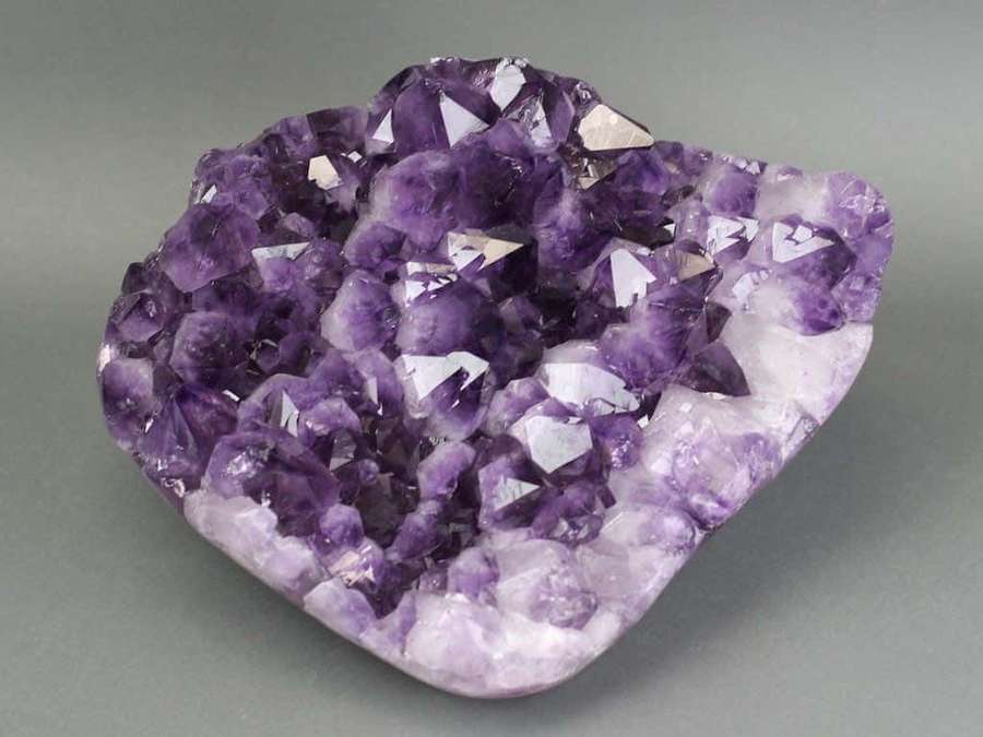 Eine natürliche Amethyst-Geode mit violetten Kristallen und weißem Quarz. — Amethyst Hintergrundbild