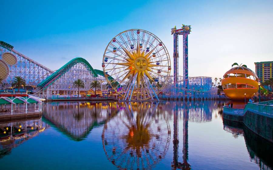 Atracciones del parque reflejadas en el agua al atardecer. — Anaheim Fondos de pantalla