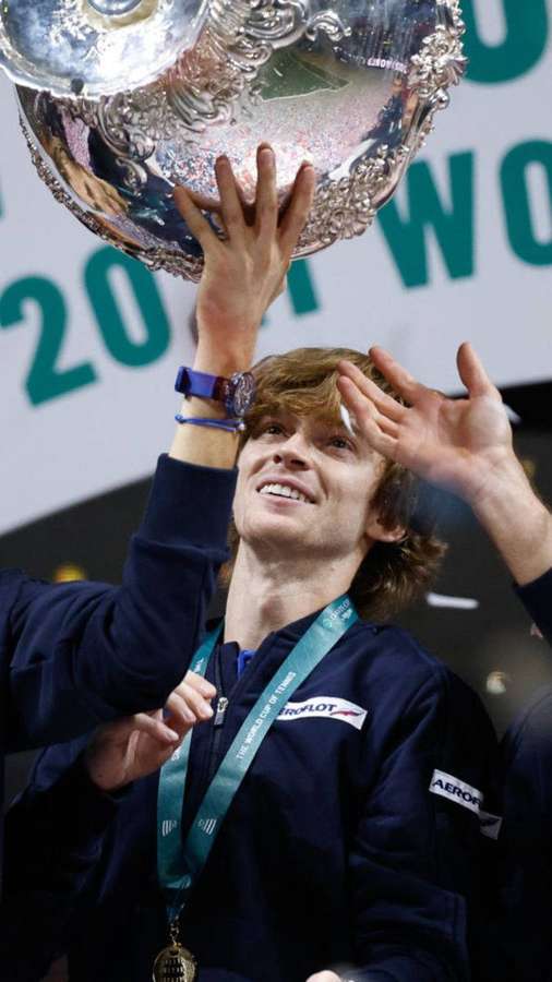 Tennis champion lifts silver trophy in victory celebration. — Andrey Rublev Wallpaper