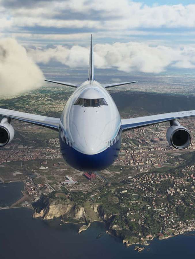 A commercial airplane flying over a coastal city with cliffs and ocean. — Android Microsoft Flight Simulator Background