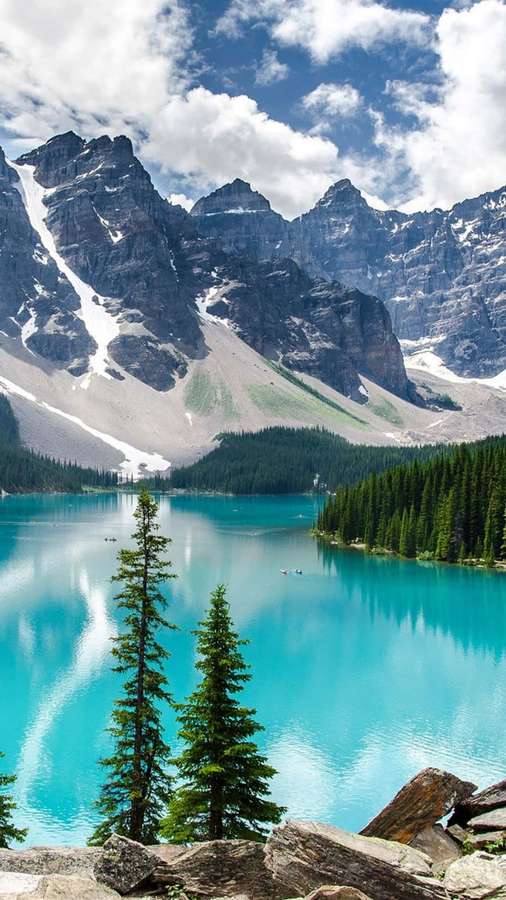 Turquoise lake surrounded by snow-capped mountains and evergreen trees under a partly cloudy sky. — Android Nature Wallpaper