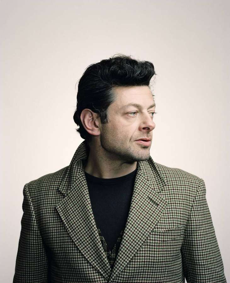 Man in houndstooth blazer and black turtleneck looking off camera in studio — Andy serkis Wallpaper