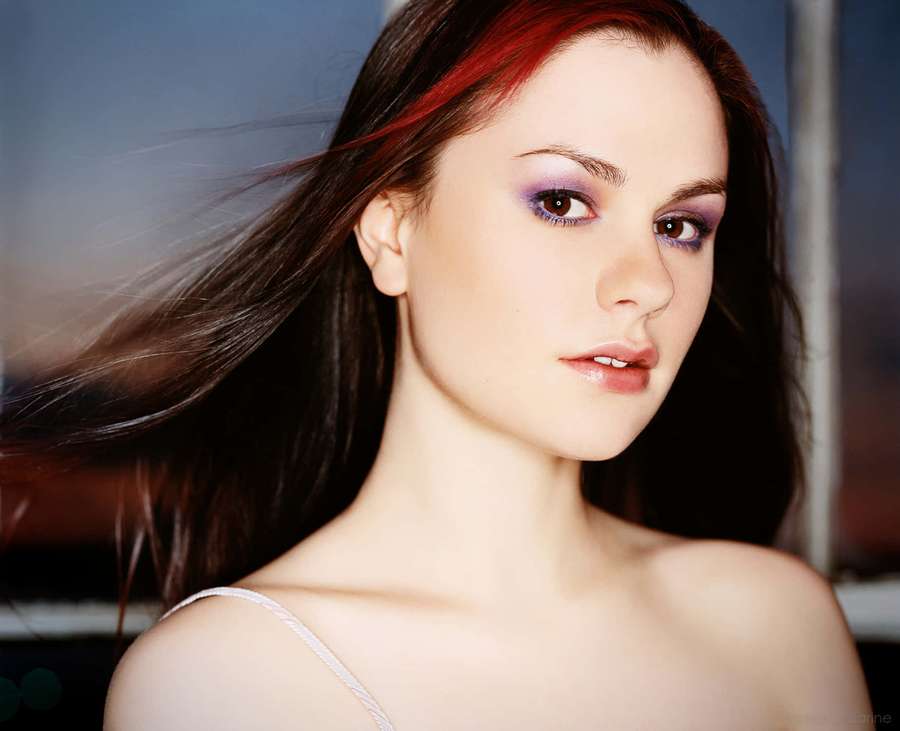 Frau mit windgepeitschtem Haar und lila Lidschatten in einem Studio-Porträt. — Anna Paquin Wallpaper