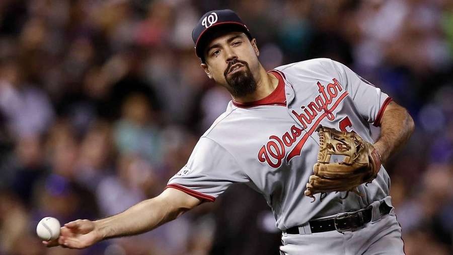 Baseball pitcher throwing a pitch during a night game with crowd in background. — Anthony Rendon Wallpaper