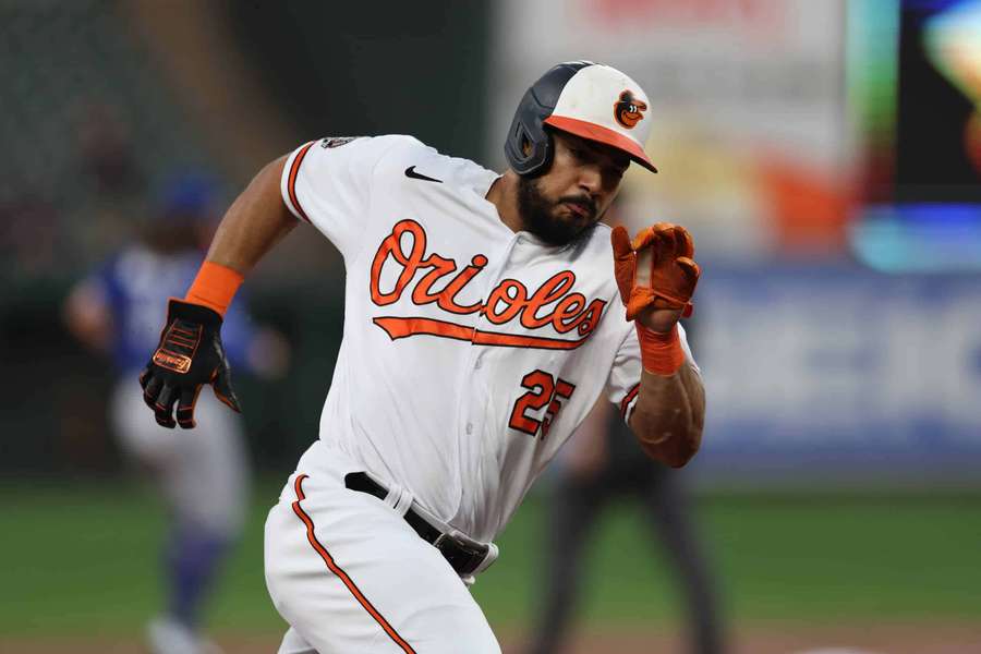 Jogador de beisebol com uniforme do Orioles correndo durante jogo noturno. — Anthony Santander Papéis de Parede
