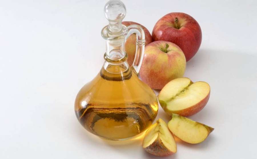 Glass bottle of apple cider vinegar with fresh apples around it. — Apple Cider Vinegar Wallpaper