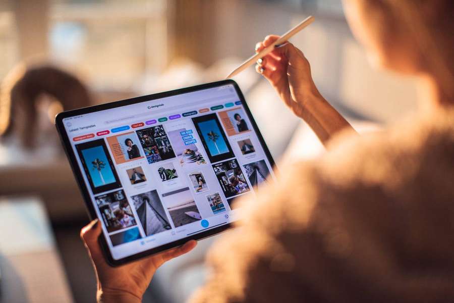 Persona navegando por plantillas de diseño en una tableta en una habitación iluminada por el sol. — Apple iPad Pro Fondos de pantalla