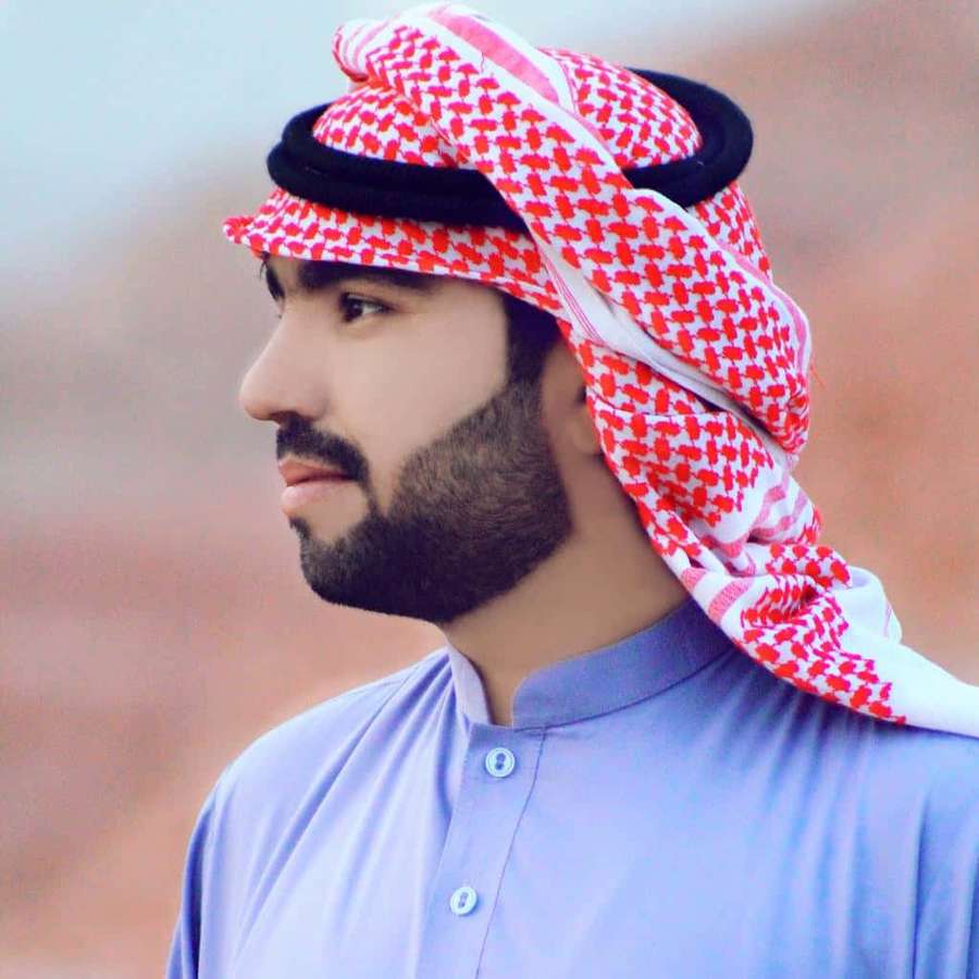 Man wearing traditional Arab headscarf and robe in desert setting — Arab Man Wallpaper