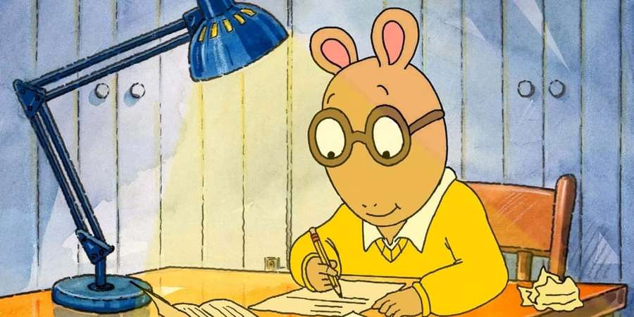 Cartoon rabbit wearing glasses writing at a desk under a blue lamp. — Arthur Picture