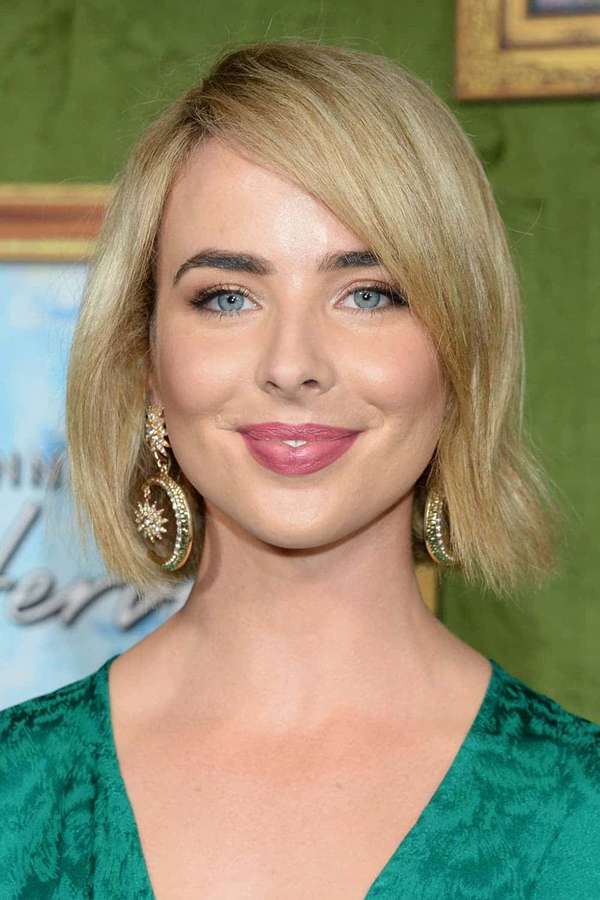 Woman with blonde hair and blue eyes wearing green velvet top and gold earrings. — Ashleigh Brewer Wallpaper