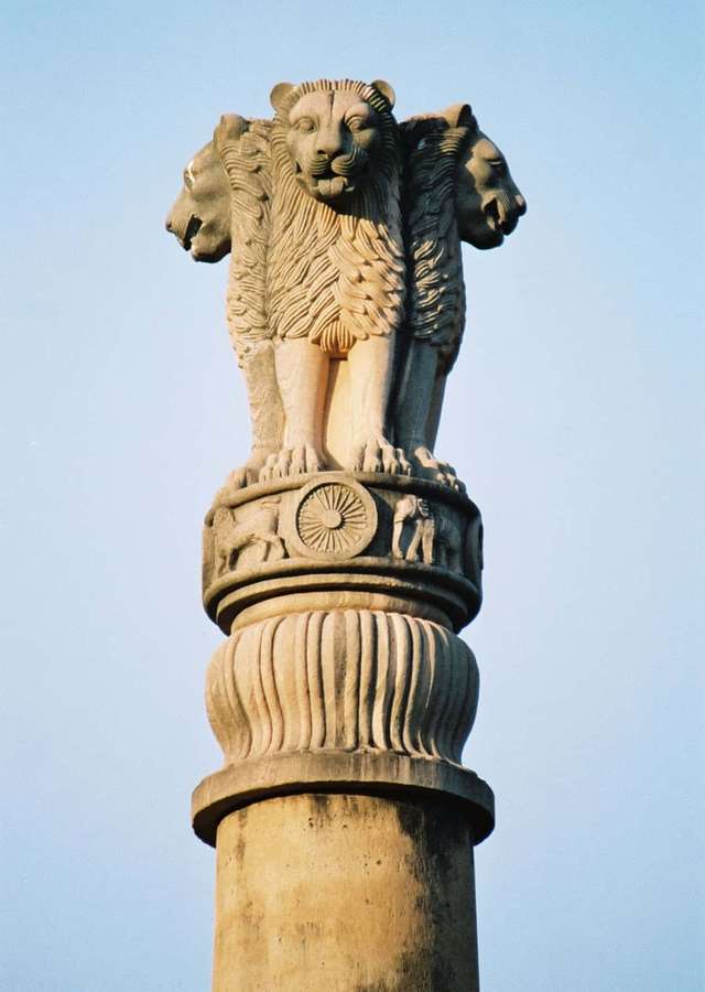 Four-headed stone lion atop a carved pillar under a clear blue sky. — Ashoka Pillar Wallpaper