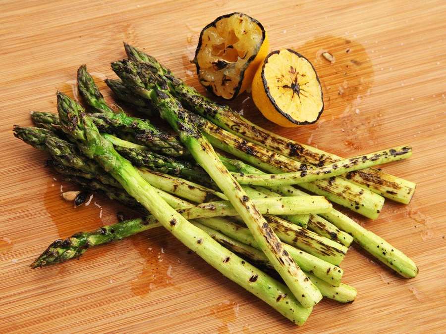 Grilled asparagus with lemon halves on a wooden board. — Asparagus Wallpaper