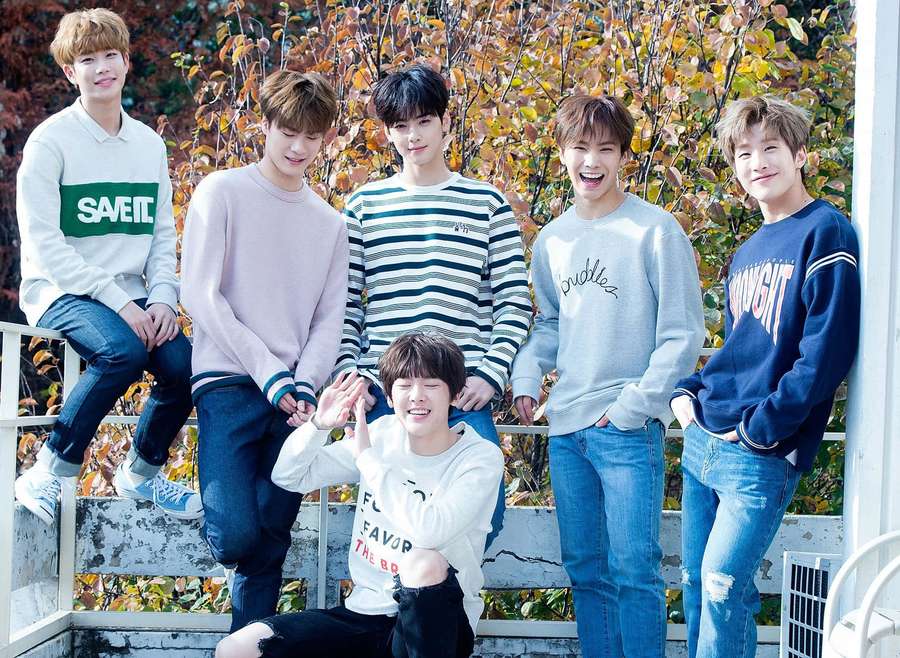 Seis jóvenes sonrientes con ropa informal de otoño posando al aire libre. — Astro Fondos de pantalla