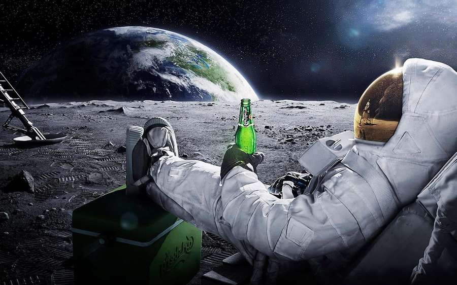 Astronaut lounging on moon with beer bottle Earth in background — Astronaut Background