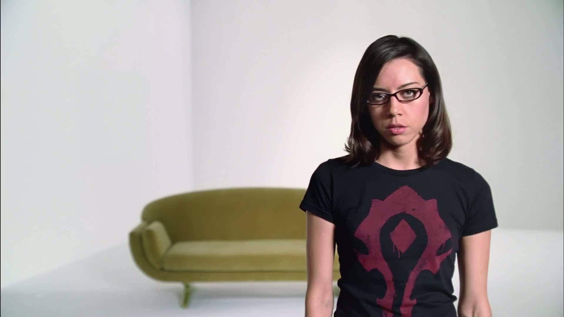 Kvinna i glasögon som bär en svart t-shirt med en röd gaming-logga inomhus. — Aubrey bakgrund Bakgrundsbilder