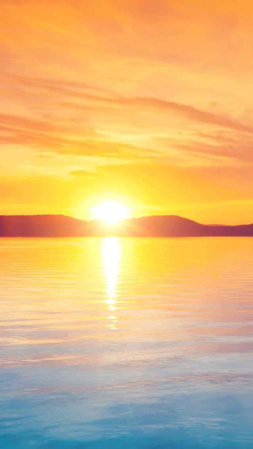 Auringonlasku tyynen järven yllä, kukkuloita kaukana — Aurinko Taustakuvat