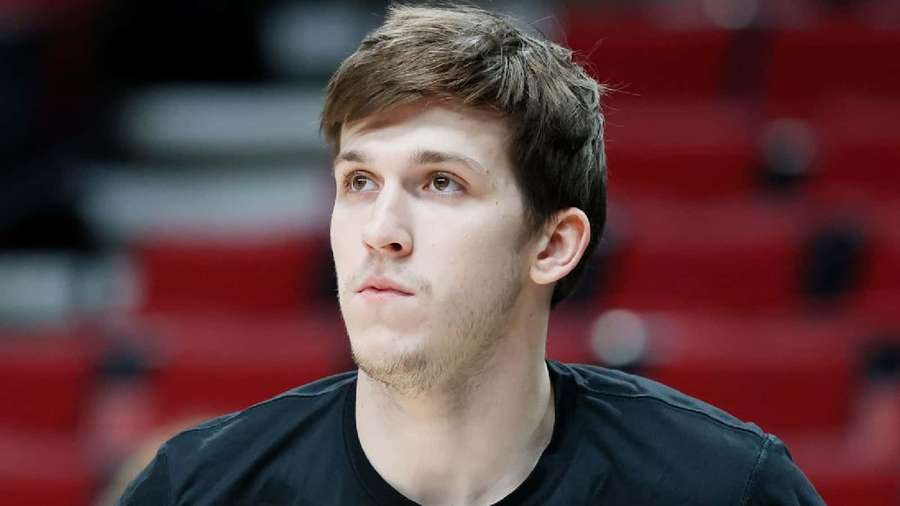 Young male basketball player looking focused during a game in a red stadium. — Austin Reaves Wallpaper