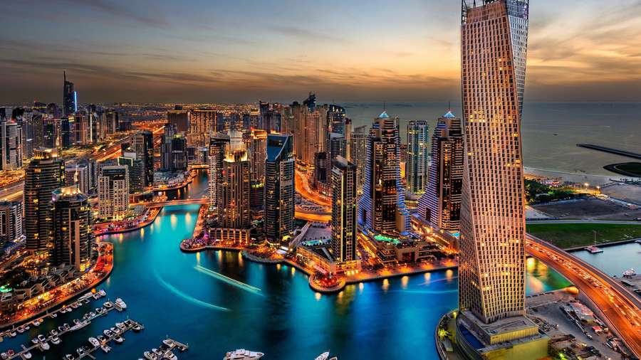 Dubai stadsbild i skymningen med glödande skyskrapor och vattenreflektioner. — Awesome HD Bakgrundsbilder