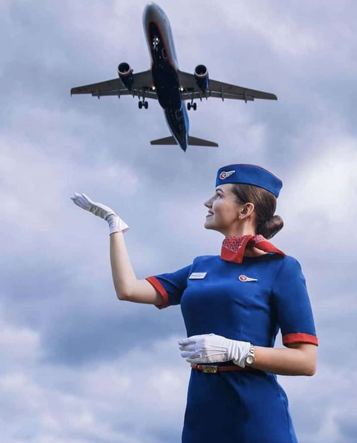 Azafata saludando mientras avión aterriza en cielo nublado — Azafata Fondos de pantalla