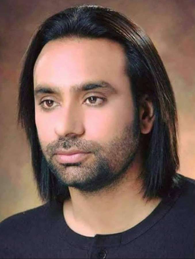Porträt eines Mannes mit langem dunklem Haar und Bart, der ein schwarzes Hemd trägt. — Babbu Maan Bilder