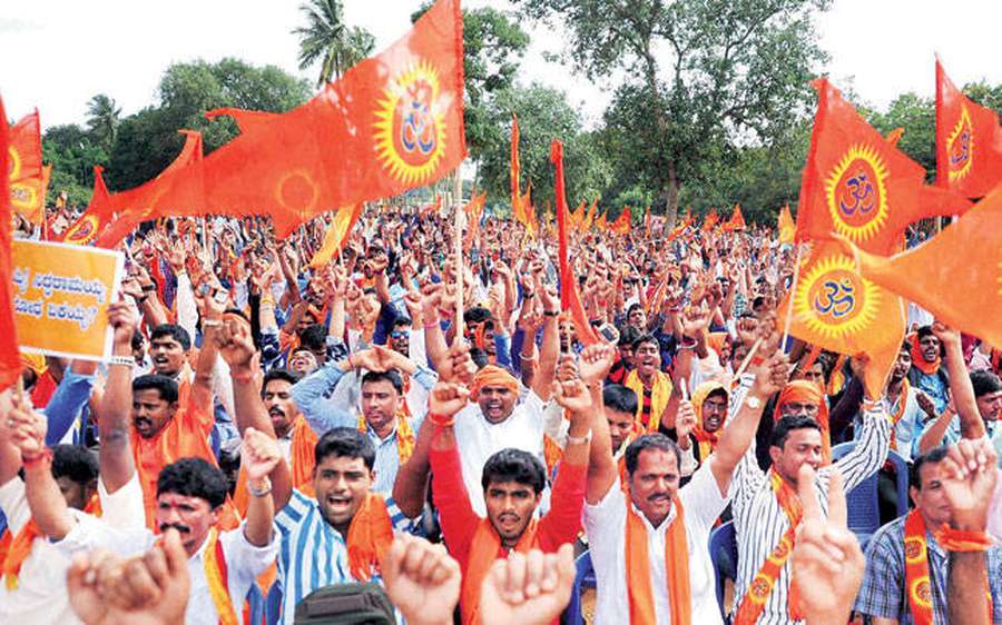 Large group of people waving orange flags and raising fists at a rally. — Bajrang Dal HD Wallpaper
