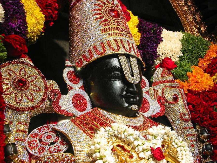 Black deity statue decorated with jewels and colorful flowers. — Balaji Wallpaper
