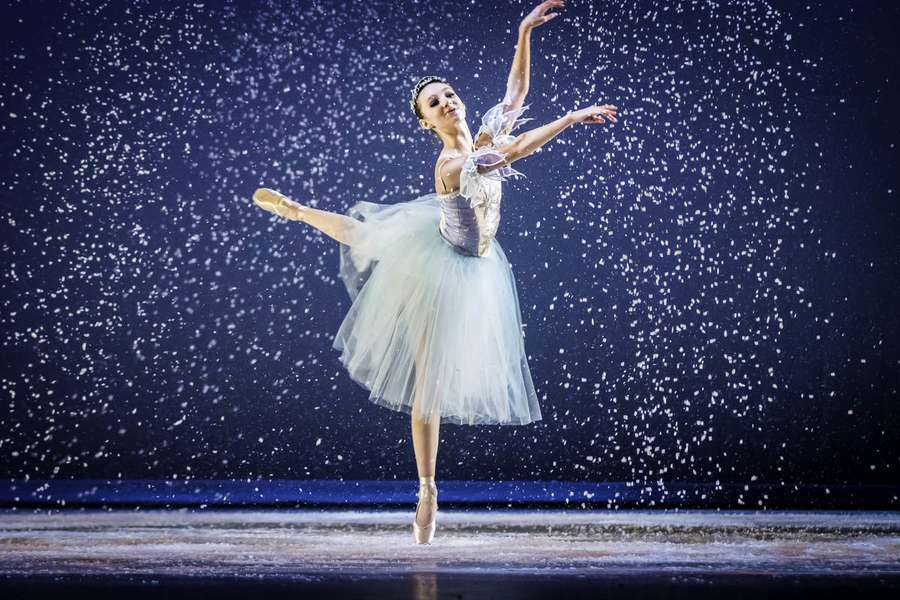 Ballerina performing ballet en pointe under falling snow on stage. — Ballet Wallpaper