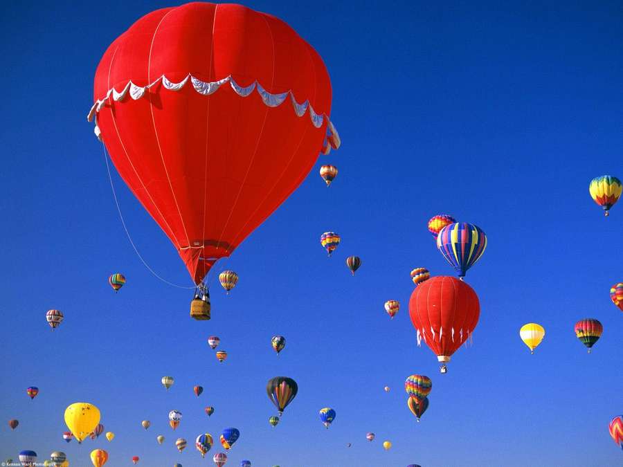 Bunte Heißluftballons schweben während eines Festivals an einem klaren blauen Himmel. — Ballon Wallpaper