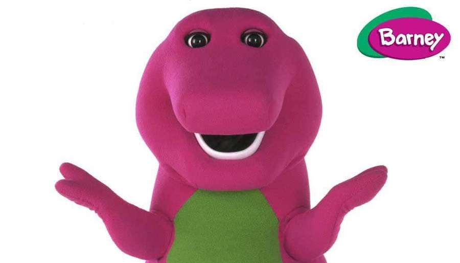Pink dinosaur puppet with green belly smiling and gesturing with open arms. — Barney Picture