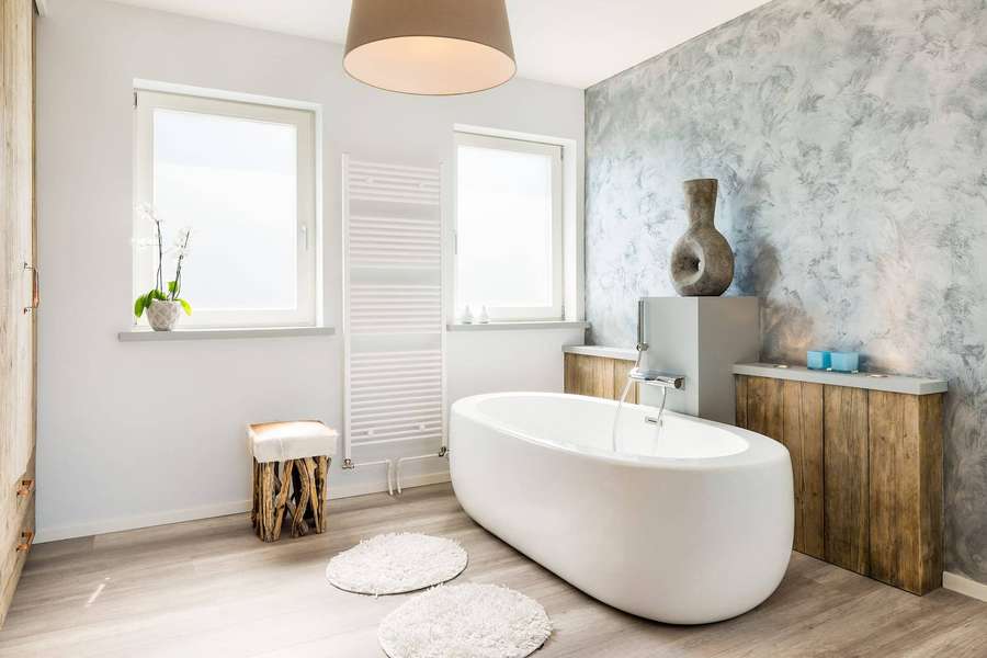 Modern bathroom with freestanding tub, wooden cabinets, and textured gray walls. — Bathtub Wallpaper